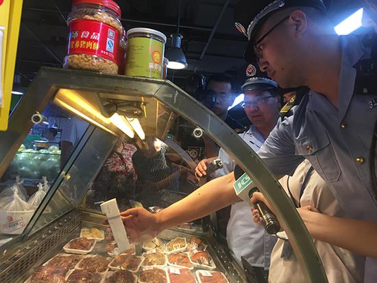 上海市食药监执法人员在家乐福超市熟食区检测储藏温度。 本文图片 澎湃新闻记者 陈伊萍 图
