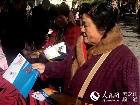 哈尔滨群众领取并阅读用药安全宣传单。