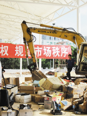 大型铲车集中销毁假冒商品。